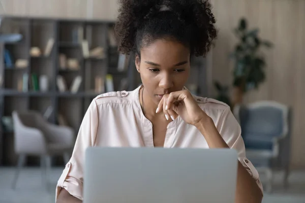 Close up thoughtful African American woman looking at laptop screen — стоковое фото