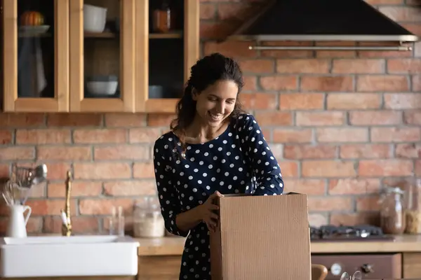 Donna felice disimballaggio scatola di cartone in cucina — Foto Stock