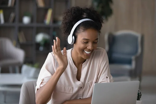 Close up smiling African American woman in headphones waving hand — Stock Photo, Image