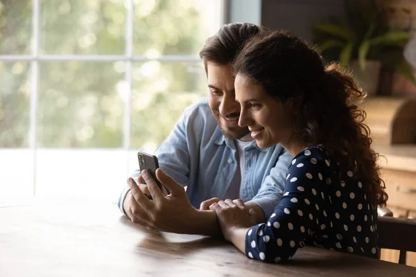 Šťastný mladý pár sdílení mobilního telefonu, sledování obsahu — Stock fotografie