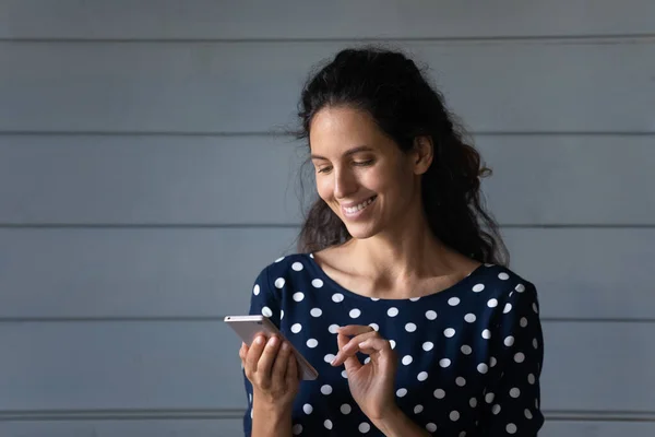 Happy pretty Latin kobieta czytanie wiadomości na telefon komórkowy — Zdjęcie stockowe