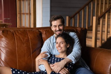 Mutlu milenyum çiftleri rahat deri koltukta dinleniyor.