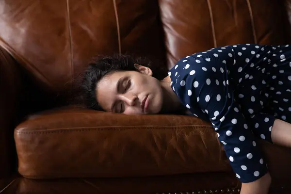 Lelah damai wanita Latin dengan mata tertutup berbaring di sofa — Stok Foto