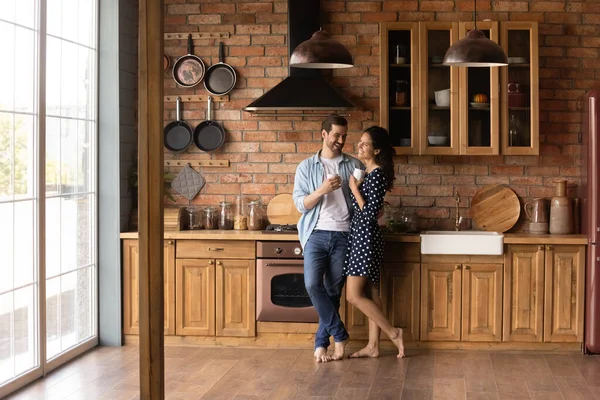 Щаслива молода подружня пара насолоджується ранковою кавою на кухні — стокове фото