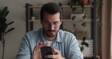 Gülümseyen milenyum adamı cep telefonu uygulamalarını evde kullanıyor..