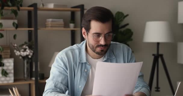 Enfocado joven 30s hombre de negocios leyendo carta de papel en casa. — Vídeo de stock