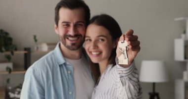 Mutlu, genç bir çift, kendi evlerinin anahtarlarını gösteriyor..