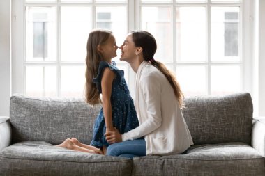 Mutlu anne ve küçük kız evde birlikte oynuyorlar.