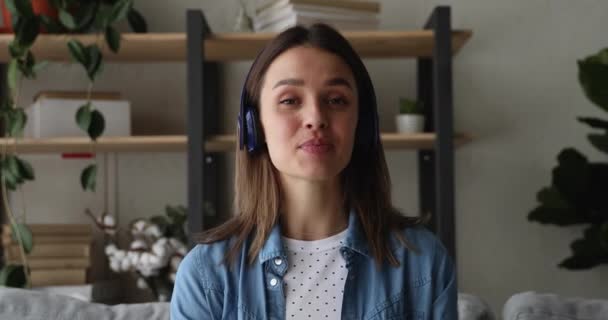 Feliz mulher milenar em fones de ouvido segurando chamada de vídeo. — Vídeo de Stock