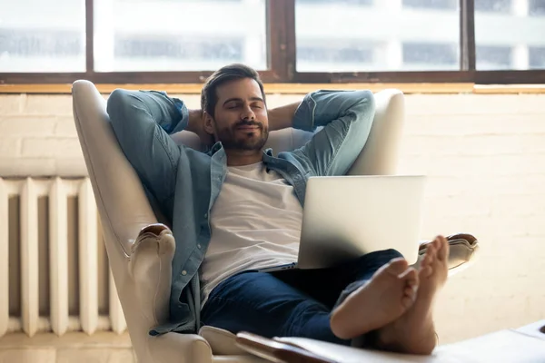 Klidný muž dokončit práci na notebooku relaxaci na koženém křesle — Stock fotografie