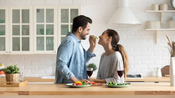 Заботливый муж кормит свою любимую жену на кухне — стоковое фото