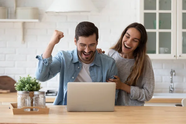 La familia que lee el correo electrónico del banco en el ordenador portátil celebra la aprobación del préstamo — Foto de Stock