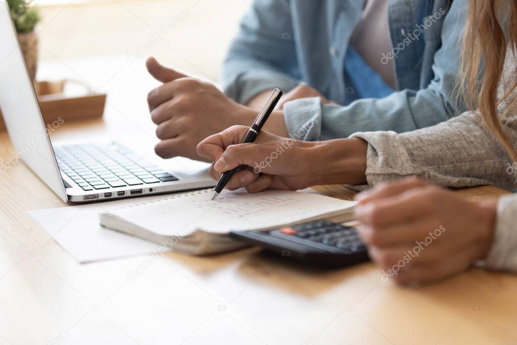 Close up spouses calculating family budget paying online using laptop