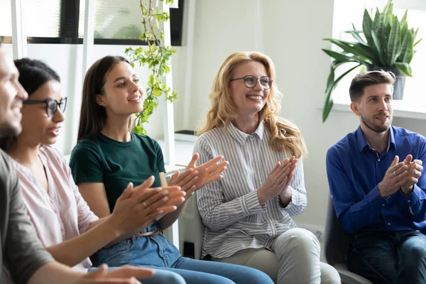 Diversa audiencia de diferentes empleados de edad aplaudiendo presentador — Foto de Stock