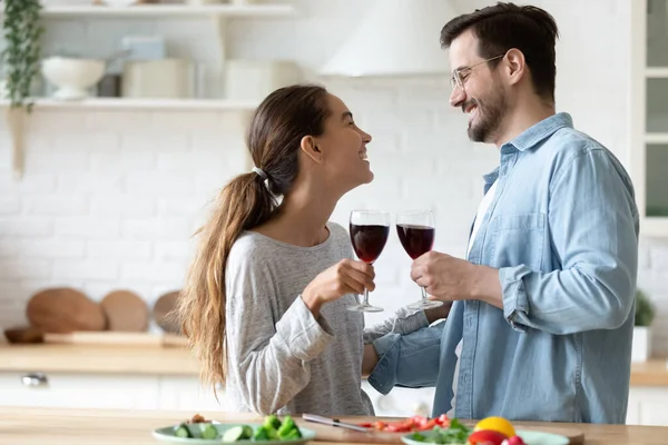 Couple tenant des verres à vin célébrer occasion spéciale debout dans la cuisine — Photo