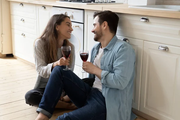 Coppia romantica seduta sul pavimento con bicchieri di vino rosso — Foto Stock