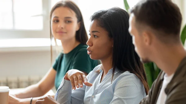 Serious mixed race employee speaking at corporate meeting — Stock Photo, Image