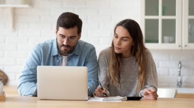 Aile bütçesi planlayan ciddi bir çift dizüstü bilgisayarında e-banka uygulaması kullanıyor