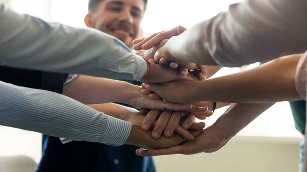 Miembros del equipo de negocios, empleados de la oficina milenaria poniendo manos juntas — Foto de Stock