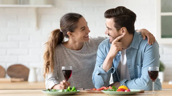 Щаслива молода пара насолоджується романтичним побаченням, стоячи на сучасній кухні — стокове фото