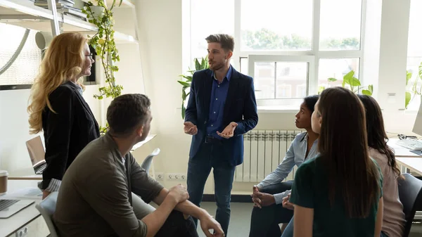 Zelfverzekerde duizendjarige bedrijfsleider, presentator spreekt voor team — Stockfoto