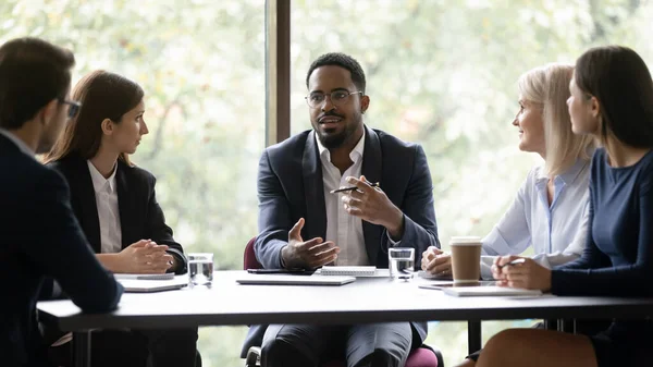 Betrokken gemotiveerde Afro-Amerikaanse bedrijfsleider in gesprek met team — Stockfoto