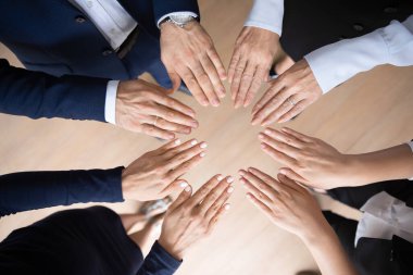 Farklı yaştaki iş adamları el şeklinde daireler çiziyor.