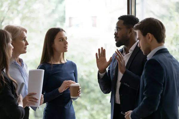 Diverse business team staan, praten op kantoor raam — Stockfoto