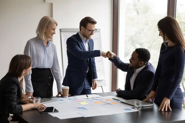 Gelukkig opgewonden diverse mannelijke kantoor maatjes maken vuist hobbel — Stockfoto