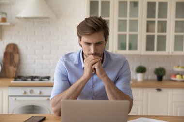 Ciddi genç iş adamları evlerinden dizüstü bilgisayarla çalışıyorlar. İyi düşün.