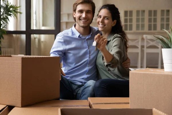 Vinculación pareja sentarse en sofá celebración de llaves día de mudanza — Foto de Stock