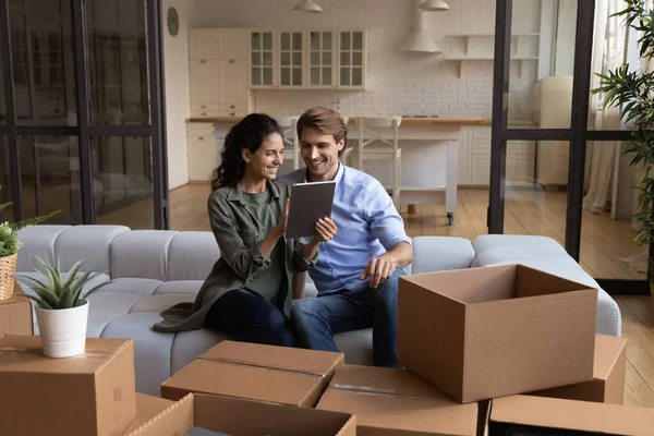 Feliz joven esposa uso tableta con el marido en la nueva casa —  Fotos de Stock