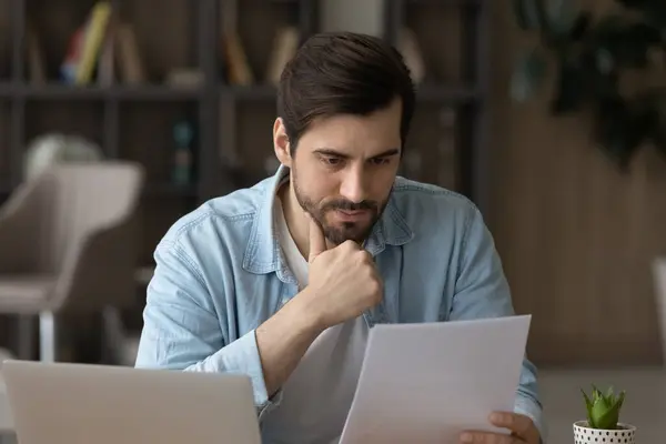 Thoughtful young businessman analyzing financial paper data. — Stock Photo, Image