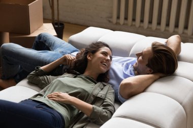 Sevgili genç eşler taşınma gününde eşyalarını boşalttıktan sonra dinleniyorlar.