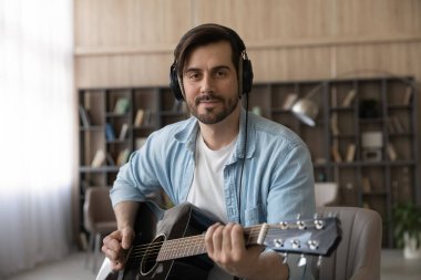 Bin yıllık profesyonel müzisyen portresi gitar tutuyor..