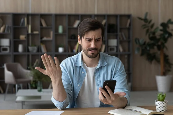 Jeune homme malheureux se sentant nerveux de mauvais travail téléphonique. — Photo