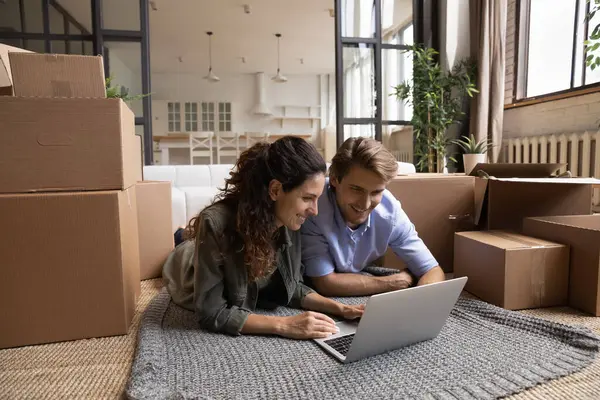 Couple choose interior design on pc online at relocation day — Stock Photo, Image