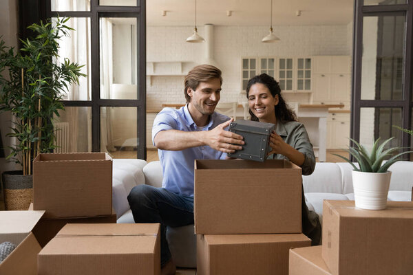 Счастливая семья распаковывает вещи после переезда в новый дом