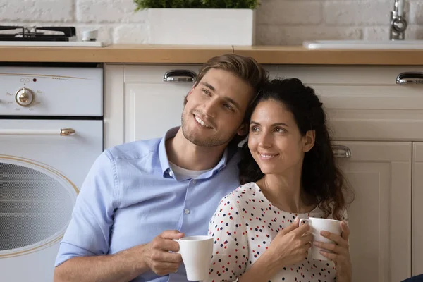 Jeune couple marié rêve à la cuisine tenir des tasses avec du thé — Photo