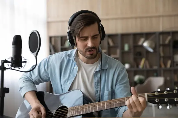 Happy millennial male musician playing guitar, recording own music. — Stock Photo, Image