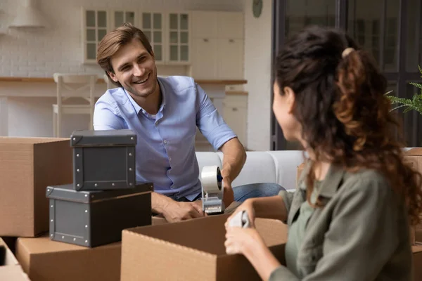 Los cónyuges millennials llenos de alegría empaquetan cosas en cajas preparadas para reubicarse — Foto de Stock