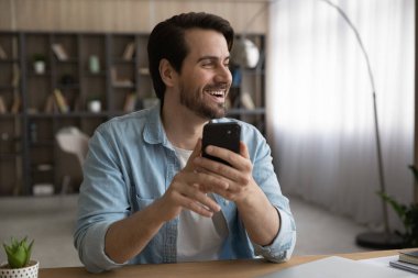 Uzaktan bakan, cep telefonu tutan hayalperest genç adam..