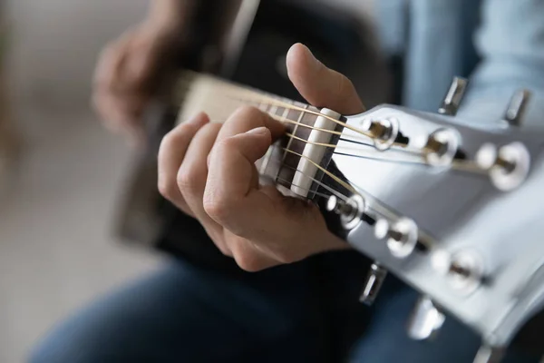 Nahaufnahme junger Mann spielt Gitarre, lernt Akkorde. — Stockfoto