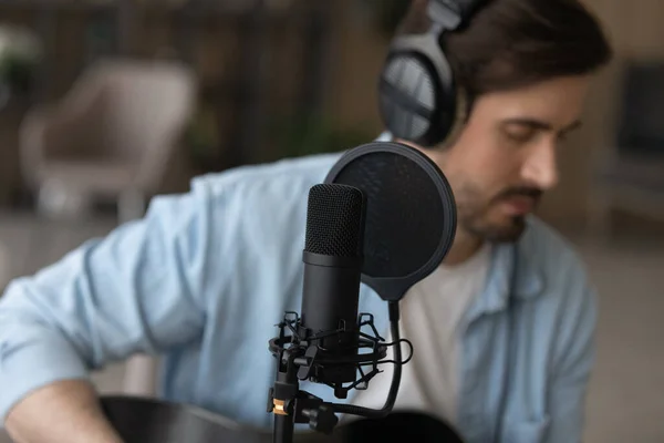 Young man in wired headphones recording own music. — Stock Photo, Image