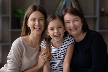 Milenyum anneleri, büyük anneleri ve küçük kızları birbirlerine sarılıyorlar.