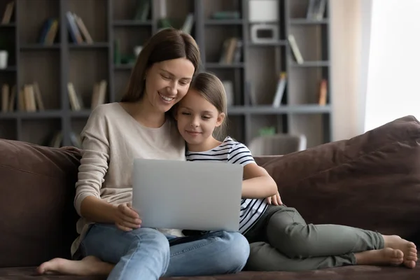 Щаслива дочка дитина і усміхнена молода мама використовує ноутбук — стокове фото