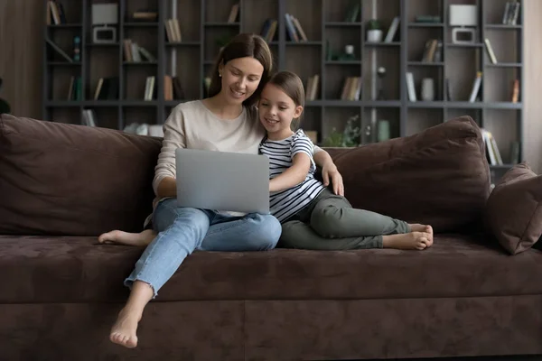 Feliz millennial mamá y hija niña relajándose en el sofá — Foto de Stock