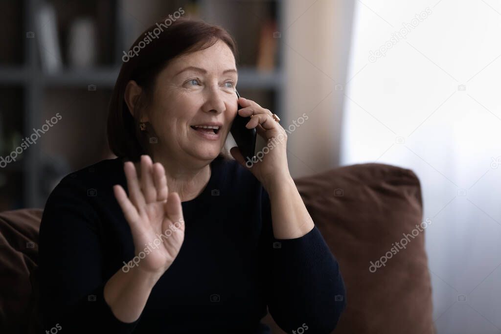 Happy senior 60s woman talking on mobile phone