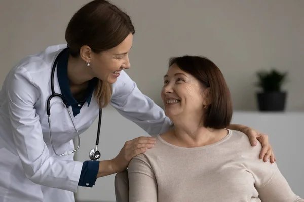 Счастливый позитивный врач, врач, медсестра, помогающая пациенту — стоковое фото