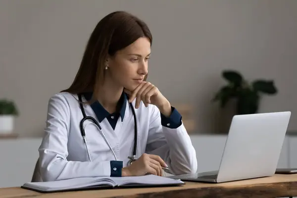 Allvarlig läkare, läkare, läkare som använder laptop, ger online konsultation — Stockfoto